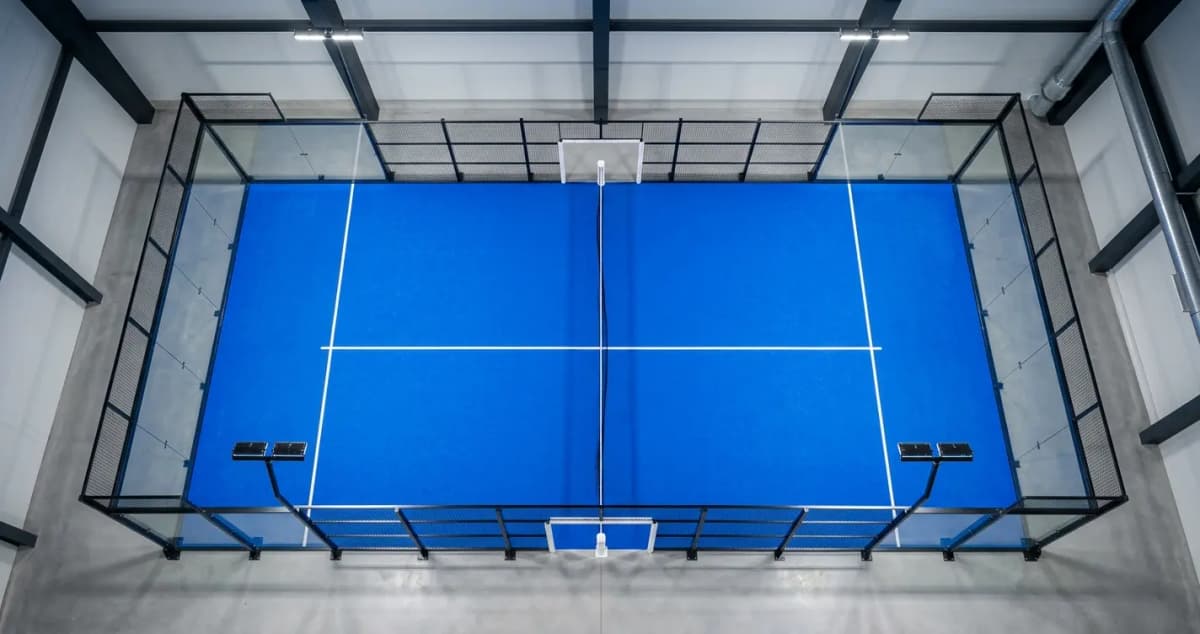 Vue d'ensemble d'un terrain de padel avec ses vitres et grillages